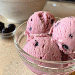 Vegan berry ice cream scoops in a glass bowl.
