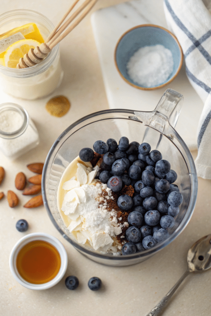 Blueberries and ingredients in a blender jar.