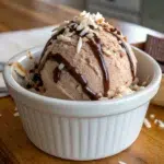 Chocolate Coconut Ice Cream Vegan 22 Vegan chocolate coconut ice cream in a white ramekin topped with chocolate drizzle and shredded coconut
