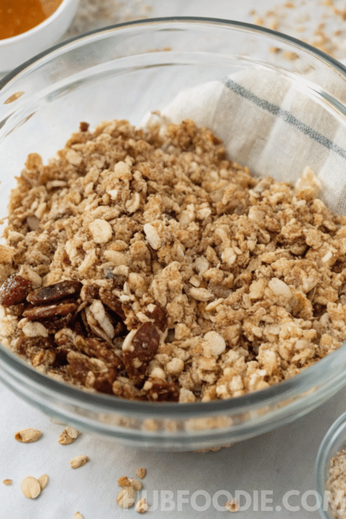 Dry ingredients for homemade gluten free granola bars mixed together in a glass bowl with oats, seeds, and nuts.