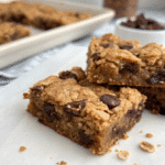 Homemade gluten free granola bars with chocolate chips, displayed on parchment paper.