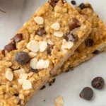 Nut Free Granola Bars Recipe 20 Nut free granola bar topped with oats, seeds, and chocolate chips on parchment paper