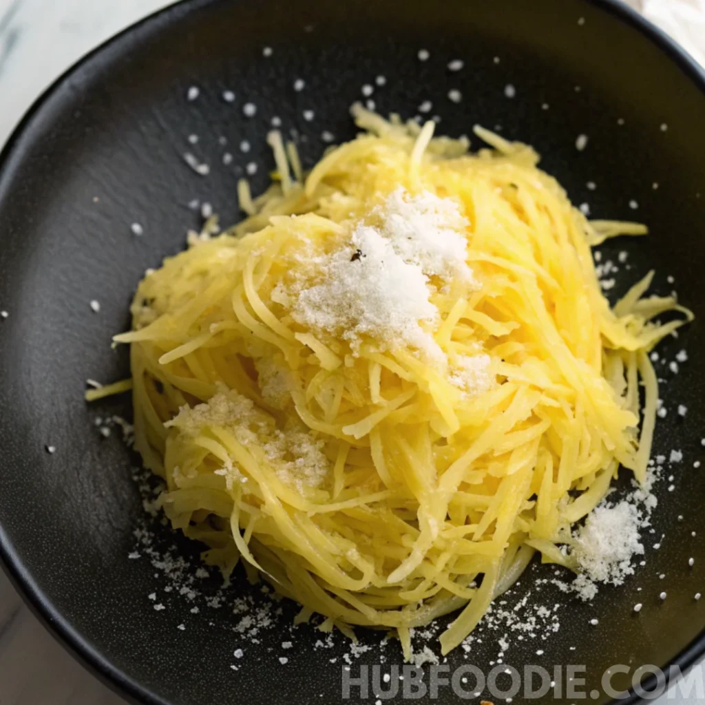 lemon squash bread recipe 23 Grated yellow squash with salt in a black bowl for squash bread preparation.